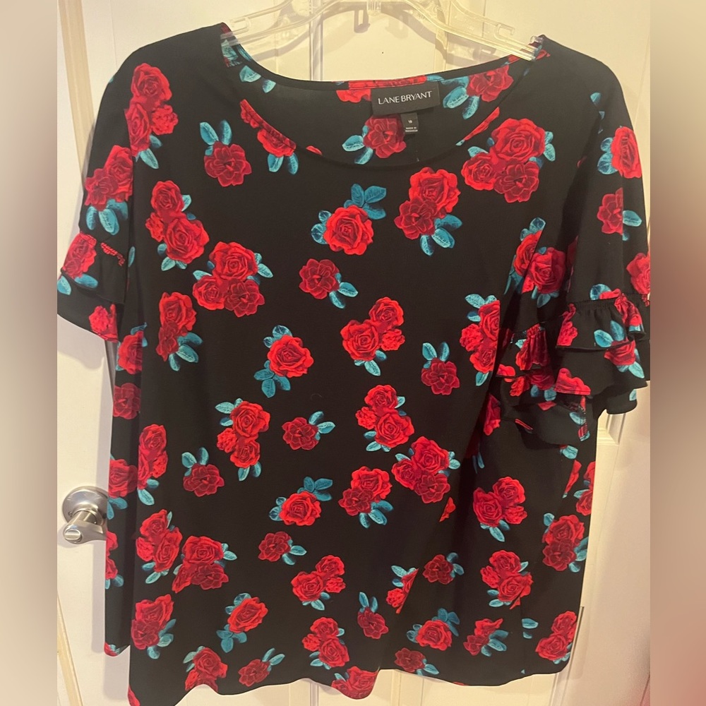 Black top with red roses and ruffled short sleeves.